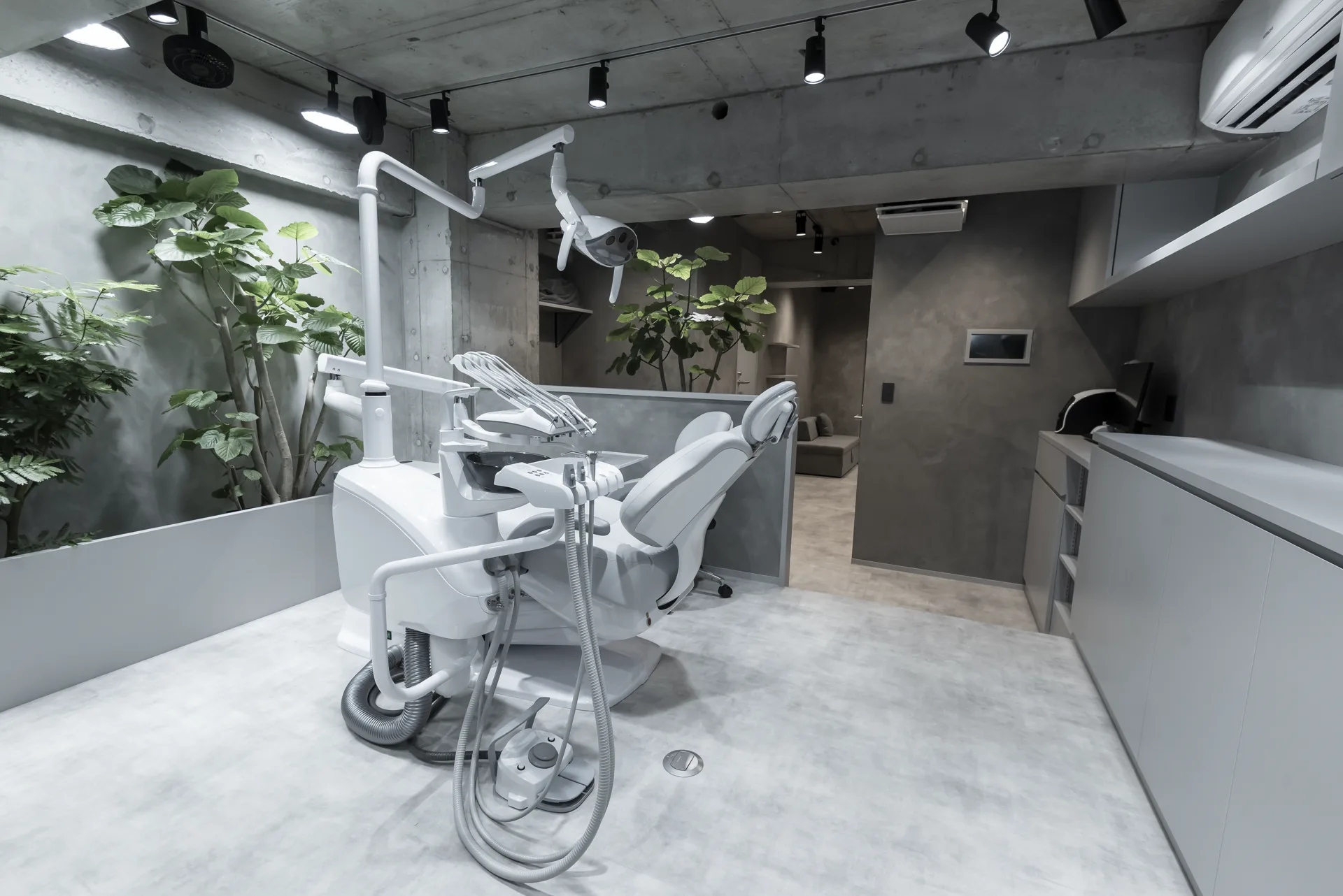 A treatment unit at 369CLINIC. A treatment room with green and exposed concrete